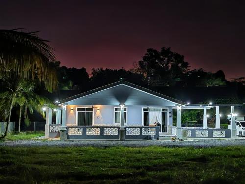 a white house with a porch at night at Homestay Villa D'Manggis in Alor Setar