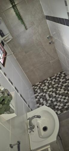 a bathroom with a toilet and a checkered floor at At lilac, Jeffreys Bay, cottage for 2 in Jeffreys Bay