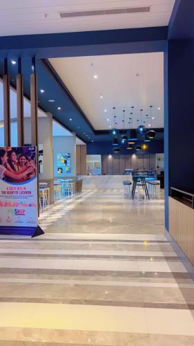 an empty lobby with tables and chairs in a building at The Royal Suites Gomti Nagar Lucknow in Lucknow