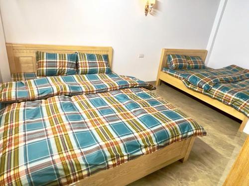 two beds sitting next to each other in a room at Homestay duy mạnh gần suối nước khoáng nóng trạm tấu in Cham Ta Lao
