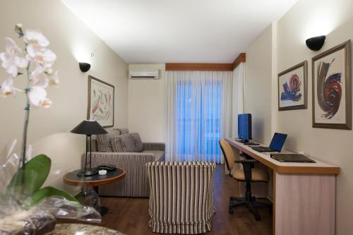 a living room with a desk with a computer on it at Metropolitan Hotel Brasília in Brasilia