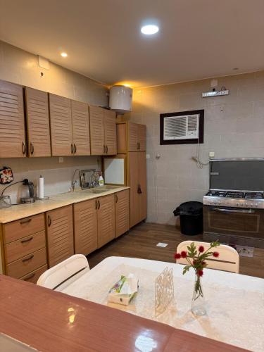 a large kitchen with wooden cabinets and a table at شاليه وفيلا اطلالة الكر in Makkah