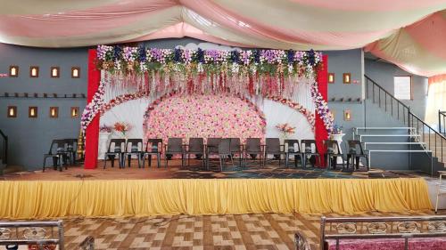a room with a stage with chairs and a pink backdrop at Madhura Agro Tourism in Wai