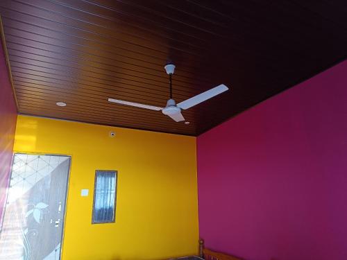 a ceiling fan in a room with colorful walls at Waves End Beach Front Stay in Gokarn