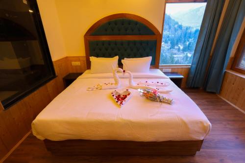 a bedroom with a bed with two hearts shaped towels at Hidden Heaven Old Manali by velvet loft in Manāli
