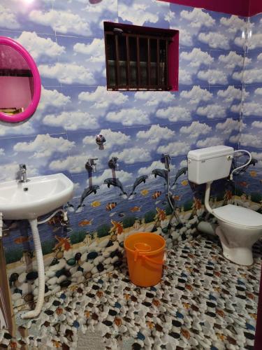 a bathroom with a sink and a toilet and clouds at Waves End Beach Front Stay in Gokarn