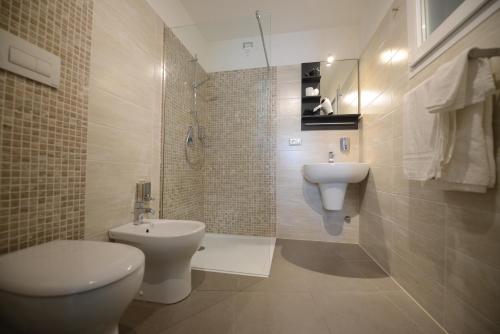 ein Bad mit einem WC und einem Waschbecken in der Unterkunft Hotel Nuova Orchidea in Dresano