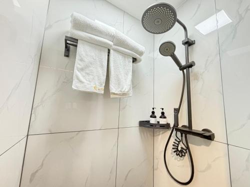 a shower in a bathroom with white tiles at Banyueli Hotel in Shanghai