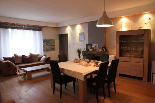 a living room with a table and chairs and a couch at La Grange des Griottiers in Saint-Priest