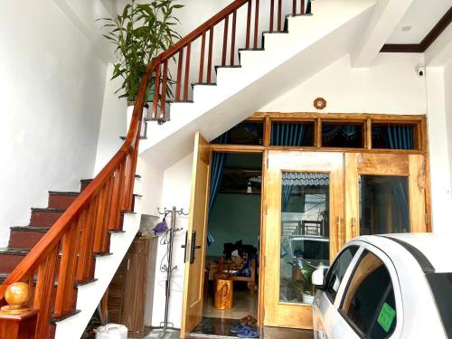 a house with a wooden staircase and a door at Homestay duy mạnh gần suối nước khoáng nóng trạm tấu in Cham Ta Lao