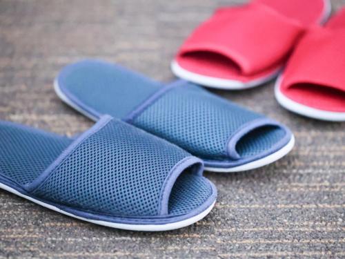 three pairs of flip flops sitting on the ground at Dormy Inn Wakkanai in Wakkanai