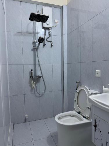 a bathroom with a shower with a toilet and a sink at Eydhafushi Home Stay Residence in Eydhafushi