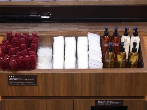 a display case with bottles of wine and towels at Dormy Inn Wakkanai in Wakkanai