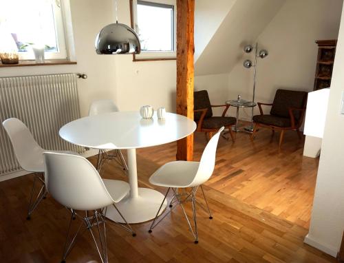 ein Esszimmer mit einem weißen Tisch und Stühlen in der Unterkunft Apartments 11 in Forchheim