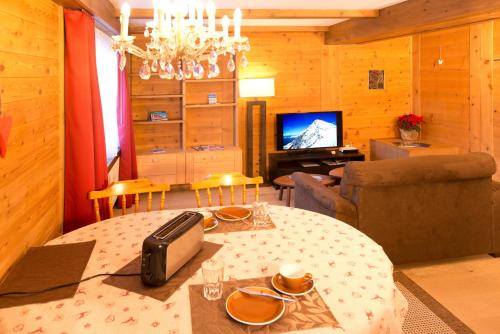 a living room with a dining table and a television at MOM - Alpine Boutique Apartments, Romantica, near Grindelwald Terminal in Grindelwald