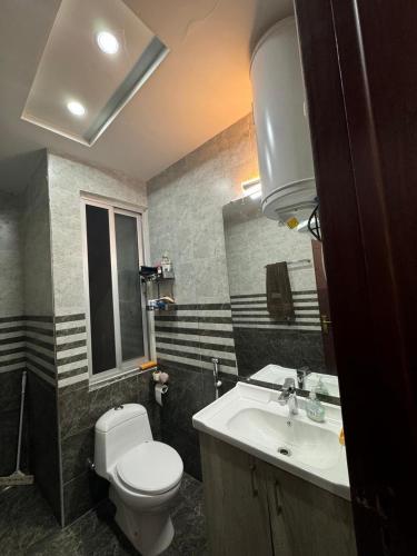 a bathroom with a white toilet and a sink at Gulberg Heights in Islamabad