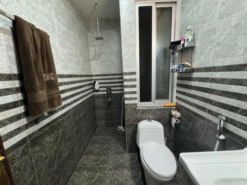 a bathroom with a toilet and a sink at Gulberg Heights in Islamabad