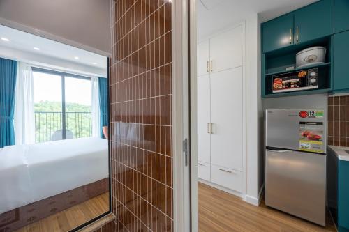 a kitchen with a refrigerator and a window at Luna Sol Villas - Dedicated Care Until Check Out in Phu Quoc