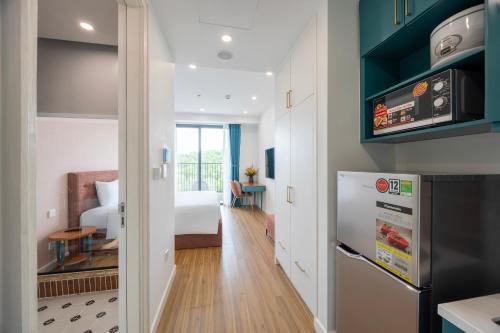 a kitchen and living room with a bed and a refrigerator at Luna Sol Villas - Dedicated Care Until Check Out in Phu Quoc