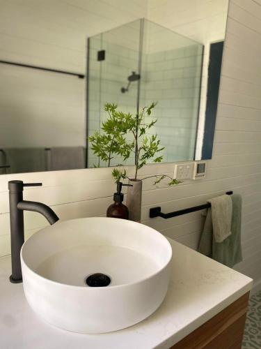 a white sink in a bathroom with a mirror at Gunuma Shack in Mount Beauty