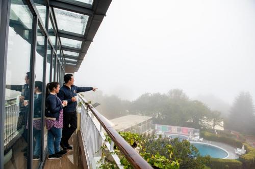 people standing on the balcony of a building looking out at the view at Pearl Continental Hotel, Bhurban in Bhurban