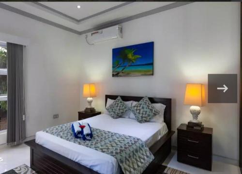 a bedroom with a large bed with two lamps at Island Charm of Praslin in Victoria