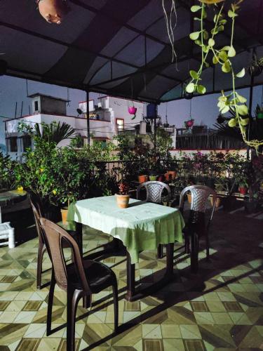 a table and chairs on a patio with an umbrella at Tulip Inn - 2BHK Rooftop AC Near Kamakhya in Guwahati