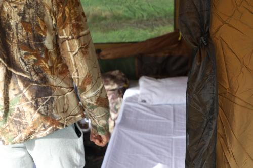 a person standing next to a bed in a tent at Gal Oya Camping in Inginiyagala