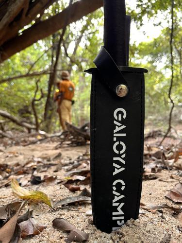 a black sign on a trail with a man in the background at Gal Oya Camping in Inginiyagala
