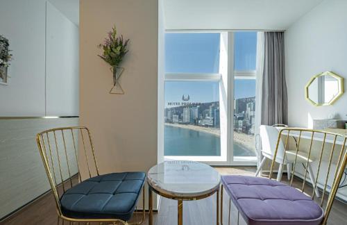 a living room with a table and chairs and a window at Gwangalli Hotel primavera in Busan in Busan