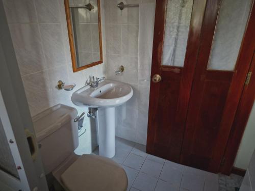 a bathroom with a sink and a toilet and a mirror at Castle villa in Hikkaduwa