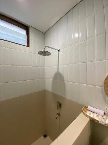 a bathroom with a shower and a tub and a sink at Agung Guest House by RF in Timuran