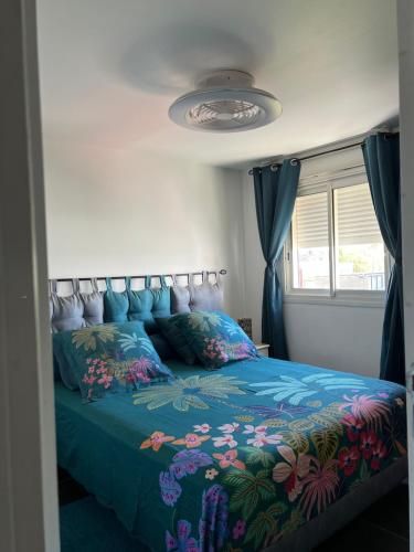 a bedroom with a bed with a blue comforter at brin de mer in Saint-Pierre