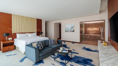 a hotel room with a bed and a couch at Fairmont Bab Al Bahr in Abu Dhabi