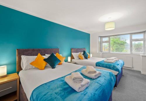 zwei Betten in einem Zimmer mit blauen Wänden in der Unterkunft Aisiki Apartments at Barnet, Ground Floor, 2-Bedroom & 1-Bathroom, Pet Friendly Flat, Double Beds with Free Wi-Fi in Barnet