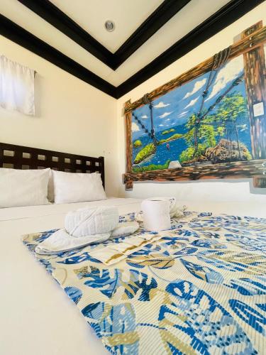 a bedroom with a bed with a painting on the wall at Bolo Hills Beach Club And Residence in Alaminos