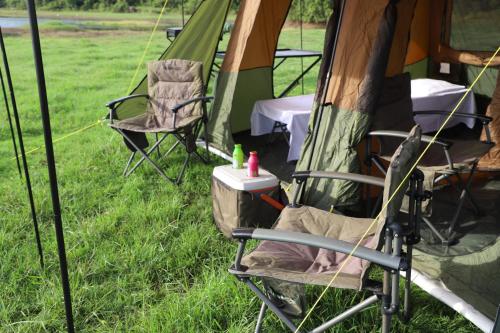 a couple of chairs sitting in front of a tent at Gal Oya Camping in Inginiyagala