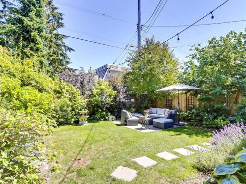 a garden with a couch and an umbrella at Private Suite With Spacious Yard in Vancouver
