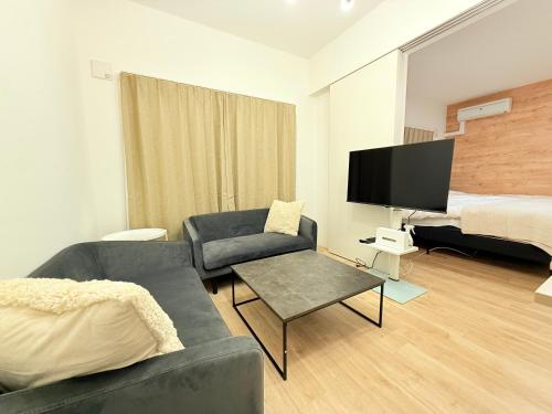 a living room with a couch and a bed at EFFECT minami7 in Sapporo