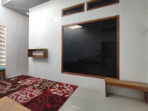 a bedroom with a large flat screen tv on the wall at Dieng Ananda Mountain View Syariah RedPartner in Kejajar