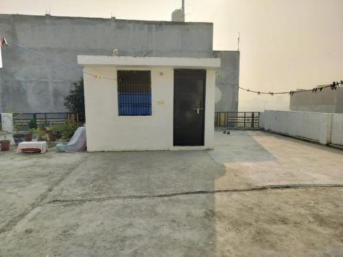 a small white building with a door on a roof at Guruu Kripaa Home Stay in Faizābād