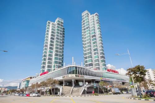 two tall buildings in a city with a parking lot at Maritime Suites Penang in Jelutong