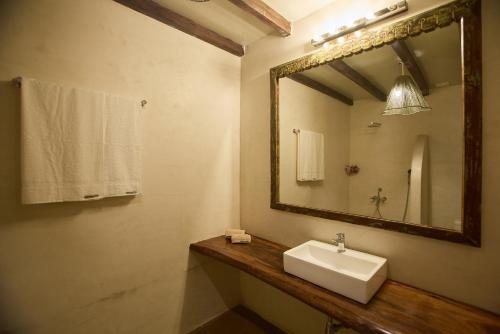 a bathroom with a sink and a mirror at Artist Beach House in Morjim