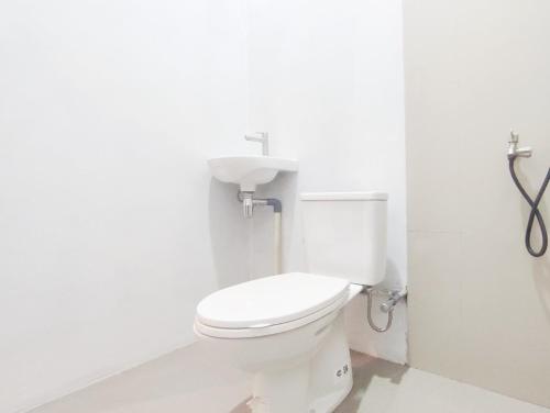 a bathroom with a white toilet in a room at Dieng Ananda Mountain View Syariah RedPartner in Kejajar
