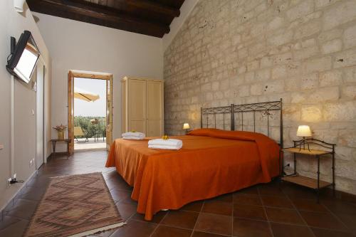 CannizzaraにあるCasa al Castelloのベッドルーム1室(オレンジ色の毛布付きのベッド1台付)