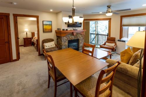 un soggiorno con tavolo in legno e camino di 1307A - One Bedroom Standard Eagle Springs West condo a Solitude