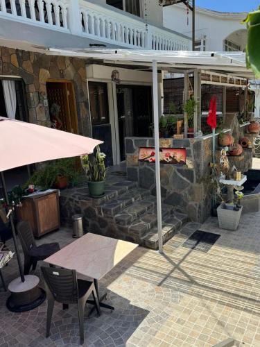 a patio with a table and an umbrella at JN sunflower residence in Le Morne