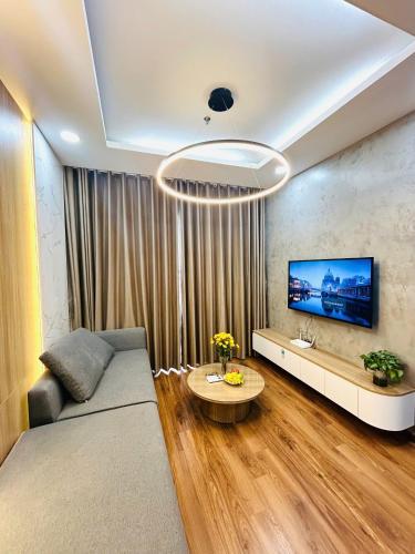 a living room with a couch and a flat screen tv at Moon Room Green Pearl Bac Ninh in Hòa Ðình