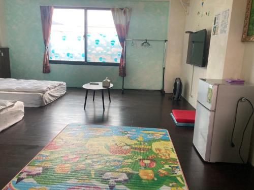 a room with a rug on the floor and a refrigerator at 福田民宿 台東民宿476號 in Guanshan