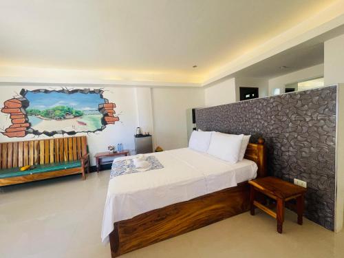 a bedroom with a bed and a painting on the wall at Bolo Hills Beach Club And Residence in Alaminos